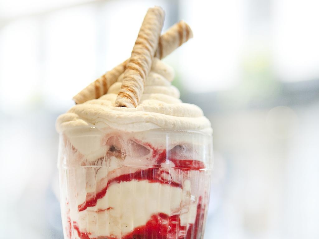 Отель Montcalm Brewery Townhouse Лондон Экстерьер фото The photo shows a delicious dessert in a clear glass dish. It features layers of creamy ice cream or whipped cream, swirled with a vibrant red fruit sauce. Topping the dessert are two rolled wafer sticks, adding a decorative touch. The overall presen